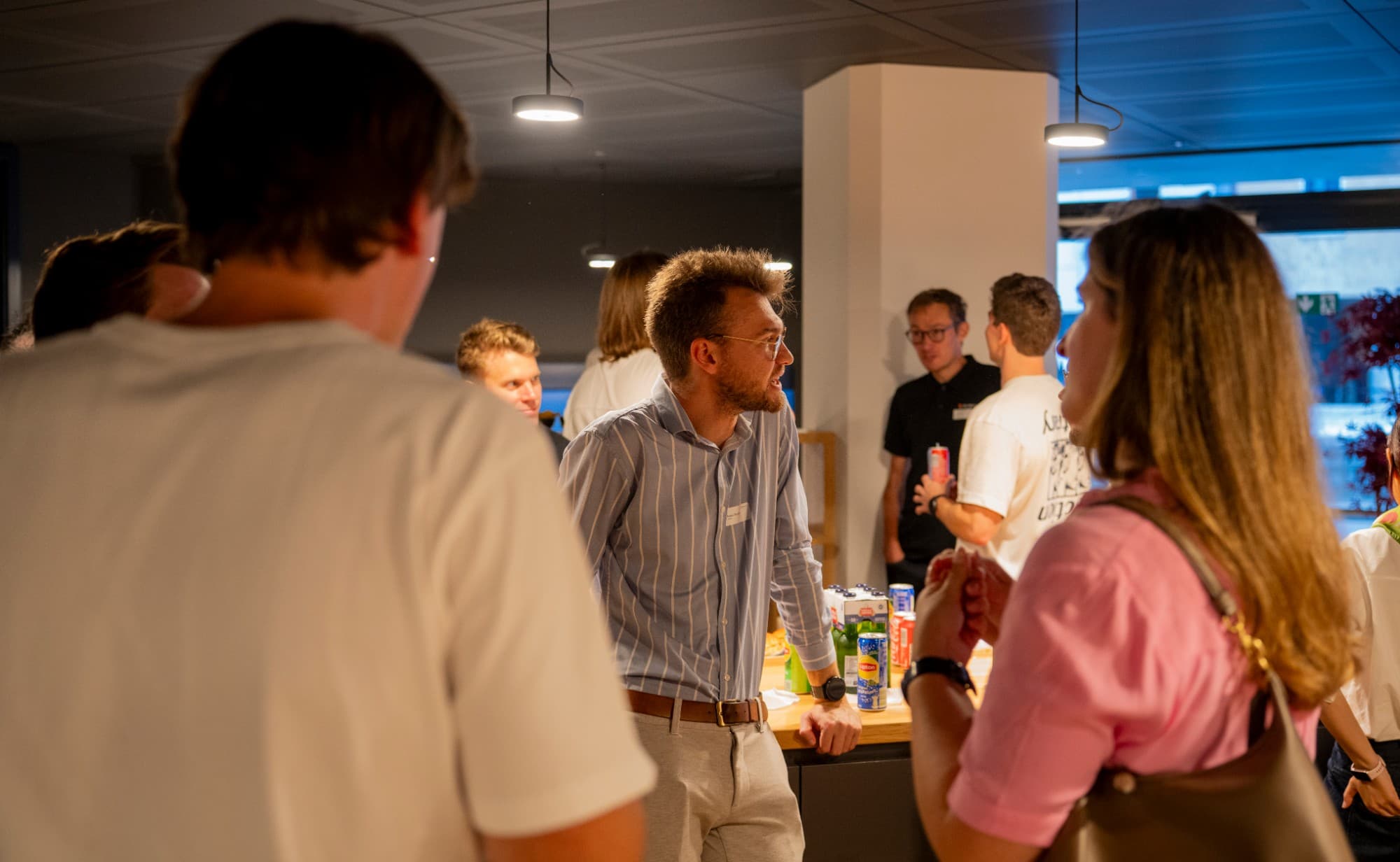 Attendees networking with drinks after the AI deployment evening session.