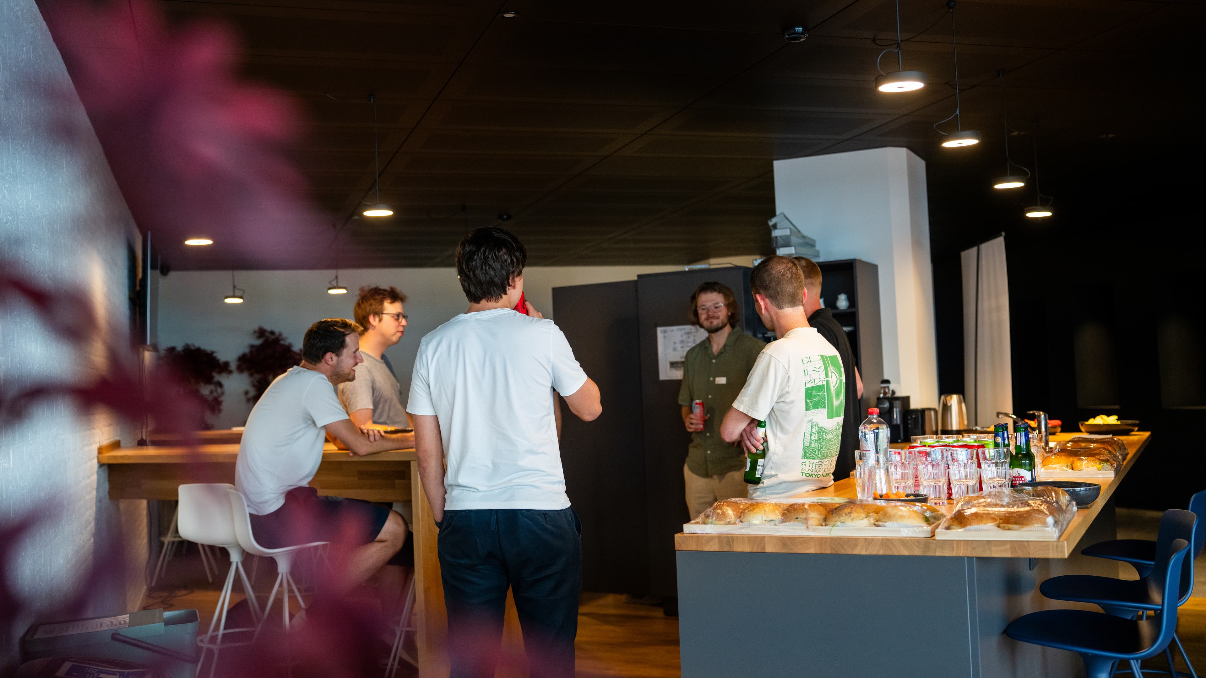 Attendees networking with drinks and food at the Panenco office kitchen.